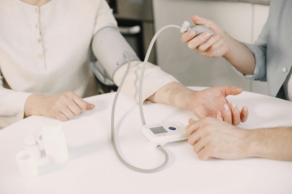A picture of a person measuring another person’s blood pressure