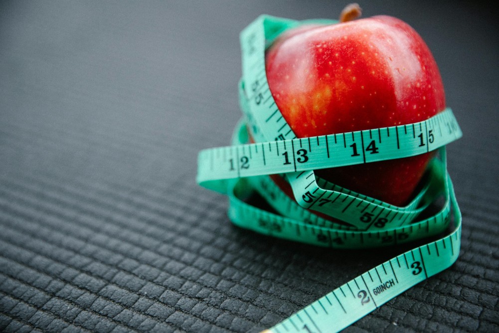 A picture of an apple wrapped around a measuring tape
